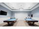 Well appointed game room with two pool tables, TV, accent lighting and neutral color palette at 6912 Gosport Cv, Bradenton, FL 34202