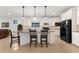 An island and white cabinets define this kitchen with bar seating, tiled floors, and stainless-steel appliances at 6912 Gosport Cv, Bradenton, FL 34202
