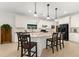 Kitchen island with granite countertop, pendant lighting, breakfast bar, and stainless-steel refrigerator at 6912 Gosport Cv, Bradenton, FL 34202