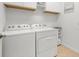 Clean laundry room with white washer and dryer, plus storage shelves and cabinets at 6912 Gosport Cv, Bradenton, FL 34202