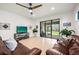 Bright living room with tile floors, ceiling fan, and sliding glass doors to the backyard at 6912 Gosport Cv, Bradenton, FL 34202