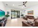 Inviting living room with tile floors, ceiling fan, and sliding glass doors leading to outdoor space at 6912 Gosport Cv, Bradenton, FL 34202