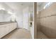 Light main bathroom with granite countertop, walk-in shower, and double doors at 6912 Gosport Cv, Bradenton, FL 34202