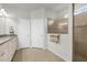 Well-lit main bathroom with double doors, tiled shower, and a granite countertop vanity at 6912 Gosport Cv, Bradenton, FL 34202