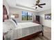 Comfortable main bedroom featuring wood floors, ceiling fan, and view to backyard at 6912 Gosport Cv, Bradenton, FL 34202