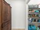 Organized walk-in pantry with shelving, a wooden cabinet, and ample storage space for food and household items at 6912 Gosport Cv, Bradenton, FL 34202