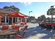 Outdoor patio with a seating area featuring red umbrellas, tables, and chairs at 7002 Dominion Ln, Lakewood Ranch, FL 34202