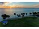 Scenic waterfront view featuring a park, fishing pier, palm trees, and a stunning sunset over the water at 750 N Tamiami Trl # 814, Sarasota, FL 34236