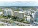 Stunning aerial view of luxury condos with meticulously landscaped grounds, pools, and convenient parking at 750 N Tamiami Trl # 814, Sarasota, FL 34236