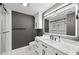A well-designed bathroom has a glass shower, a vanity with black hardware, and a large illuminated mirror at 750 N Tamiami Trl # 814, Sarasota, FL 34236