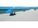 Expansive beach view featuring a pristine shoreline, clear turquoise water, and relaxing beach umbrellas at 750 N Tamiami Trl # 814, Sarasota, FL 34236