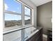 A bright bedroom view showcases a dark wood dresser, a large window, and an expansive city skyline at 750 N Tamiami Trl # 814, Sarasota, FL 34236