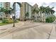 Beautiful entrance to the condo building with manicured landscaping and brick paved street at 750 N Tamiami Trl # 814, Sarasota, FL 34236