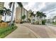 Elegant condo building entrance framed by lush tropical landscaping and palm trees at 750 N Tamiami Trl # 814, Sarasota, FL 34236