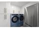The laundry room is equipped with front-load washer and dryer units and ample storage cabinets at 750 N Tamiami Trl # 814, Sarasota, FL 34236