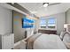 A modern bedroom features a ceiling fan, mounted TV, and a large window with an amazing city view at 750 N Tamiami Trl # 814, Sarasota, FL 34236