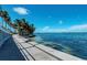 Scenic waterfront view along a concrete walking path lined with lush palm trees and beautiful blue waters at 750 N Tamiami Trl # 814, Sarasota, FL 34236