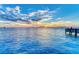 Tranquil waterfront view with calm water and a fishing pier and a colorful sunset sky at 750 N Tamiami Trl # 814, Sarasota, FL 34236