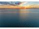 Broad waterfront view displaying calm waters and a distant skyline with a colorful sunset at 750 N Tamiami Trl # 814, Sarasota, FL 34236
