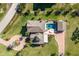 An aerial view of a well-maintained property with a pool, lush landscaping, and a brick driveway at 766 Bayshore Dr, Terra Ceia, FL 34250