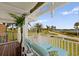 Inviting covered balcony with views of the lush, landscaped property and neighborhood at 766 Bayshore Dr, Terra Ceia, FL 34250