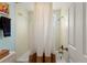 Cozy bathroom featuring a bathtub with a stylish shower curtain, tiled walls and nautical decor at 766 Bayshore Dr, Terra Ceia, FL 34250