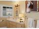 Charming bathroom with decorative mirror, wall sconces, artwork, and white cabinets at 766 Bayshore Dr, Terra Ceia, FL 34250