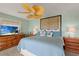 Comfortable bedroom with a blue comforter, wood furniture, and a ceiling fan at 766 Bayshore Dr, Terra Ceia, FL 34250