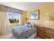 Bright bedroom with neutral carpet, patterned decor, and a large window with a view of the front yard at 766 Bayshore Dr, Terra Ceia, FL 34250