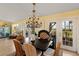 Cozy dining room features french doors, a unique chandelier, and seating for at least five people at 766 Bayshore Dr, Terra Ceia, FL 34250