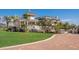 Exterior view of a landscaped waterfront property with a well-manicured lawn and brick driveway at 766 Bayshore Dr, Terra Ceia, FL 34250