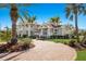Beautiful home featuring brick driveway, manicured lawn, lush landscaping, and mature palm trees at 766 Bayshore Dr, Terra Ceia, FL 34250