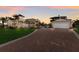 Beautiful home featuring a brick driveway, lush green lawn, and garage with upstairs balcony overlooking the pool at 766 Bayshore Dr, Terra Ceia, FL 34250