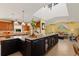 Open kitchen featuring custom cabinetry, stone countertops, a large center island, and views into the living room at 766 Bayshore Dr, Terra Ceia, FL 34250