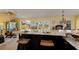 Open concept kitchen with an island and stone countertops overlooks the living spaces and the exterior water views at 766 Bayshore Dr, Terra Ceia, FL 34250