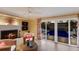 Cozy living room featuring a fireplace, comfortable wicker seating, and a sliding glass door to the pool area at 766 Bayshore Dr, Terra Ceia, FL 34250