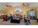 Cozy living room featuring high ceilings, ceiling fans, decor with ocean-inspired accents, and a large arched window at 766 Bayshore Dr, Terra Ceia, FL 34250