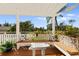 Inviting covered outdoor seating area featuring charming decor and a delightful view of the surrounding landscape at 766 Bayshore Dr, Terra Ceia, FL 34250