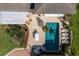 Aerial view of a private backyard oasis featuring a sparkling pool, patio area, pergola, and lounge chairs at 766 Bayshore Dr, Terra Ceia, FL 34250