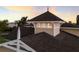 A detailed rooftop with a pointed turret-like section, brown shingles, and cream colored siding under a colorful evening sky at 766 Bayshore Dr, Terra Ceia, FL 34250