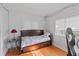 Cozy bedroom features hardwood floors, a comfortable bed, and bright natural light from the window at 7735 Westmoreland Dr, Sarasota, FL 34243
