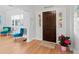 Bright and inviting entryway featuring a wooden door, stylish decor, and hardwood floors at 7735 Westmoreland Dr, Sarasota, FL 34243