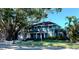 Charming two-story home featuring a well-manicured lawn, beautiful landscaping, and mature trees at 7735 Westmoreland Dr, Sarasota, FL 34243