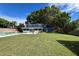 Large backyard with a two-story home, pool, mature trees, and lush lawn creates a private oasis at 7735 Westmoreland Dr, Sarasota, FL 34243