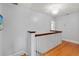 Upstairs hallway featuring wood floors and white banister at 7735 Westmoreland Dr, Sarasota, FL 34243