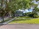 Charming two-story home with a large banyan tree, lush lawn and manicured landscaping at 7735 Westmoreland Dr, Sarasota, FL 34243
