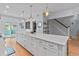 Spacious kitchen featuring a large island with ample storage, pendant lighting, and hardwood floors at 7735 Westmoreland Dr, Sarasota, FL 34243