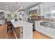 Spacious kitchen featuring white cabinetry, stainless steel appliances, a large island with seating, and hardwood floors at 7735 Westmoreland Dr, Sarasota, FL 34243