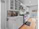 Modern kitchen with stainless steel appliances, granite countertops, white cabinetry, and a tiled backsplash at 7735 Westmoreland Dr, Sarasota, FL 34243