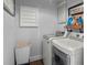 Functional laundry room featuring modern washer and dryer units and overhead shelving at 7735 Westmoreland Dr, Sarasota, FL 34243